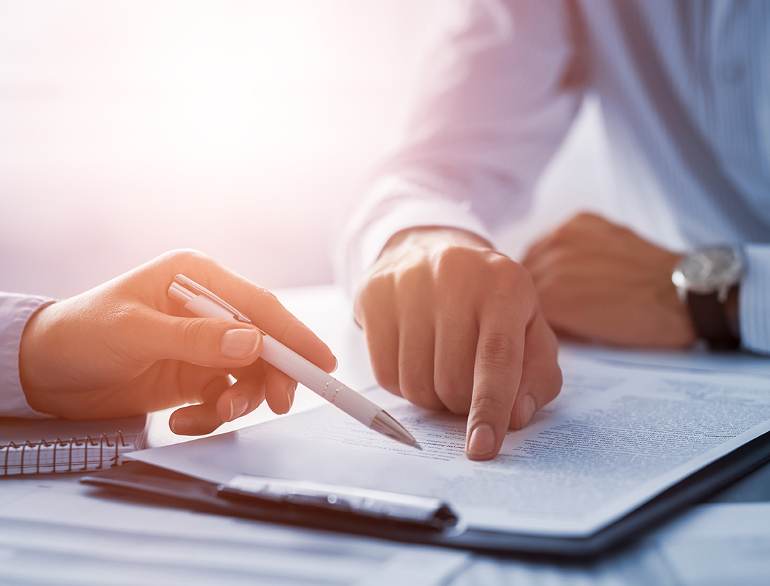 Business people negotiating a contract. Human hands working with documents at desk and signing contract.